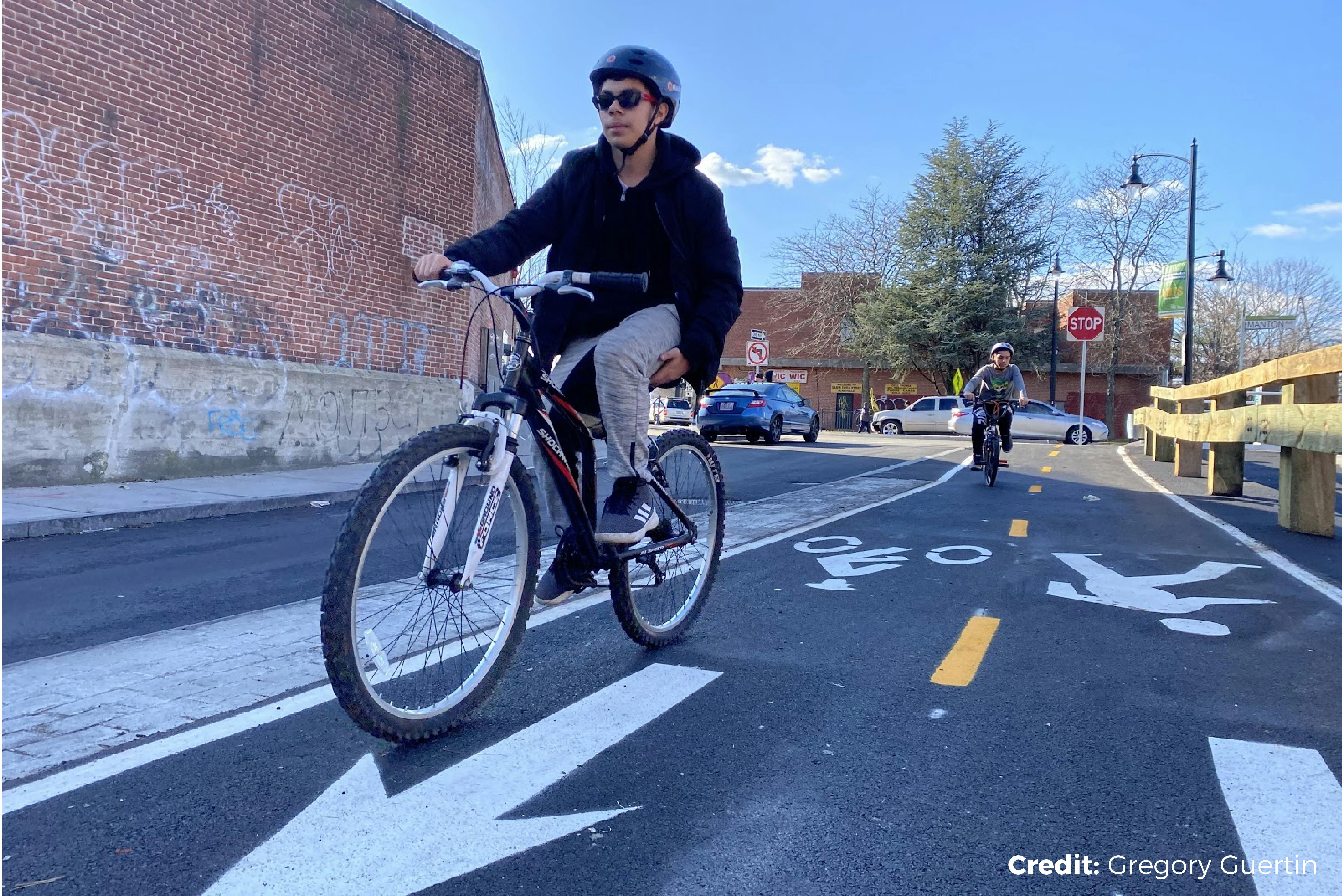 Cyclists riding on a protected bike lane in an urban setting