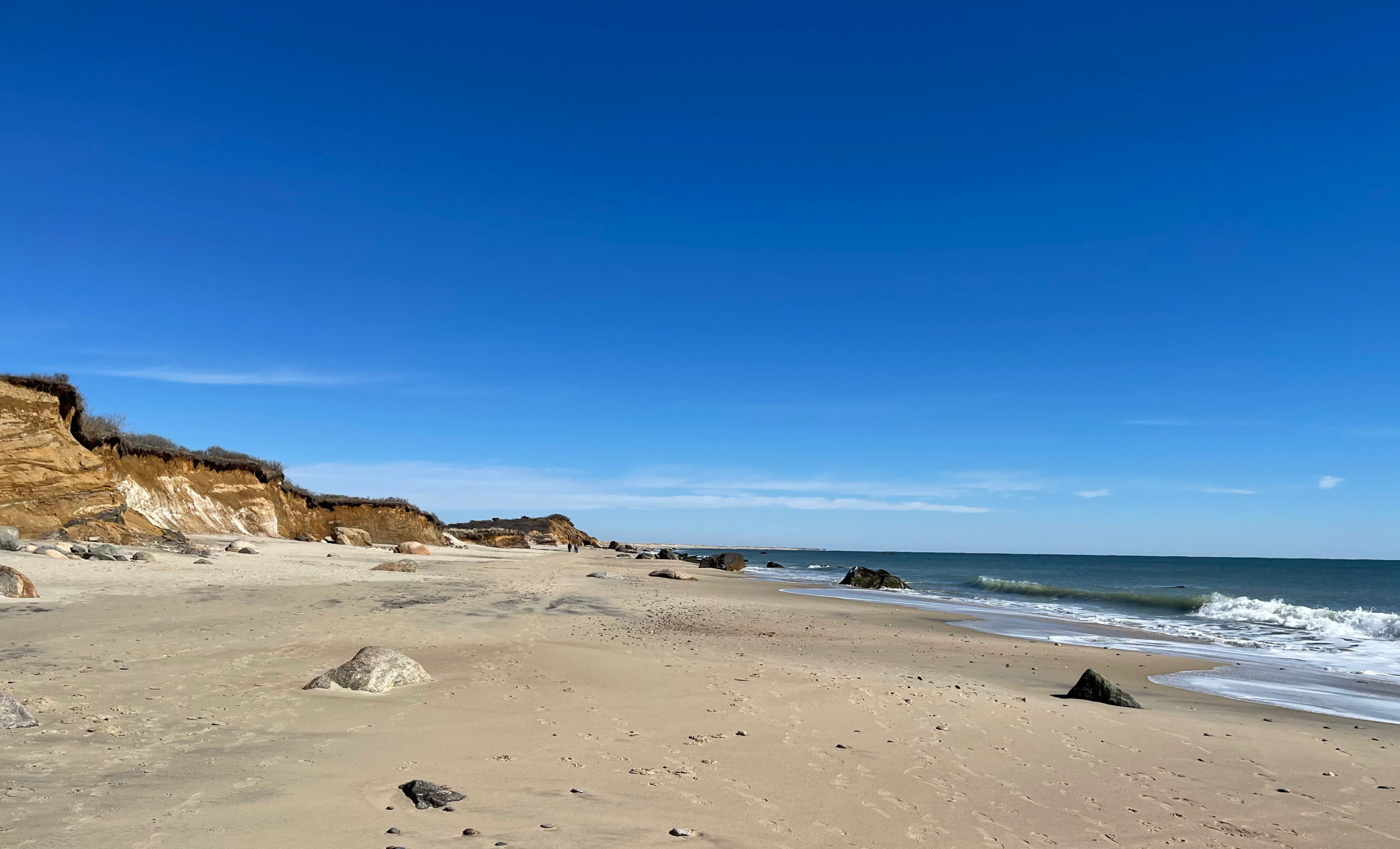 Scenic Martha's Vineyard coastline with colorful cottages along beach at sunset