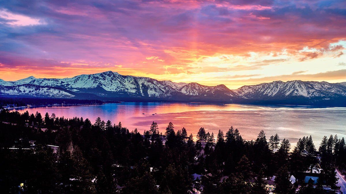 Stunning sunset view of Lake Tahoe with crystal clear blue water and mountains in background