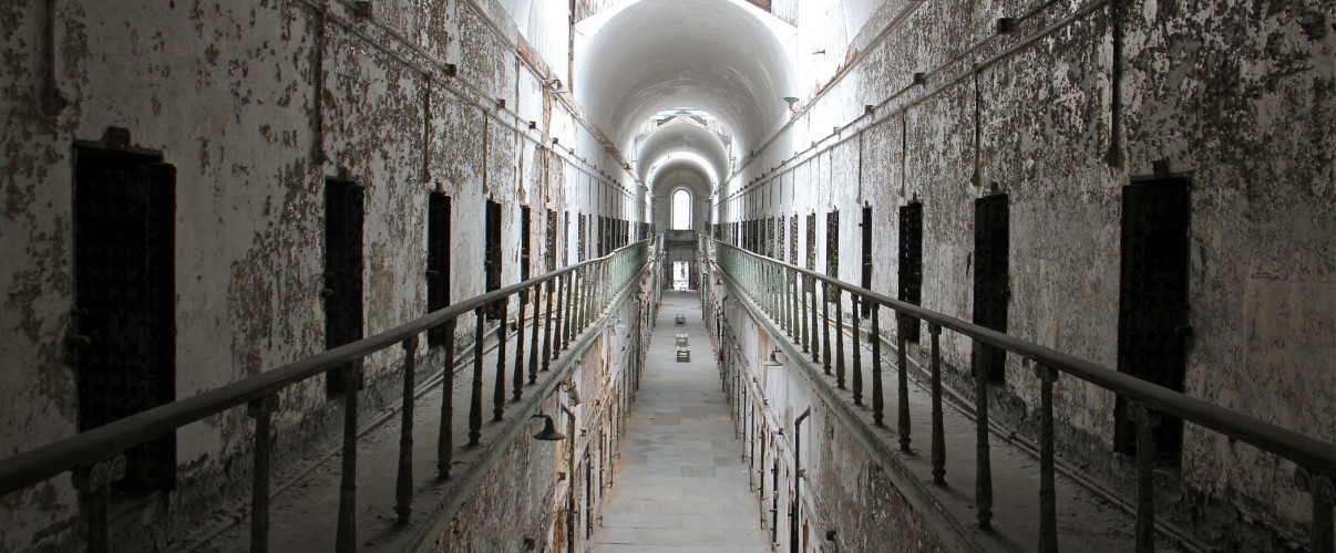 Eastern State Penitentiary haunted Dark abandoned corridor in Eastern State Penitentiary with peeling walls and eerie lighting