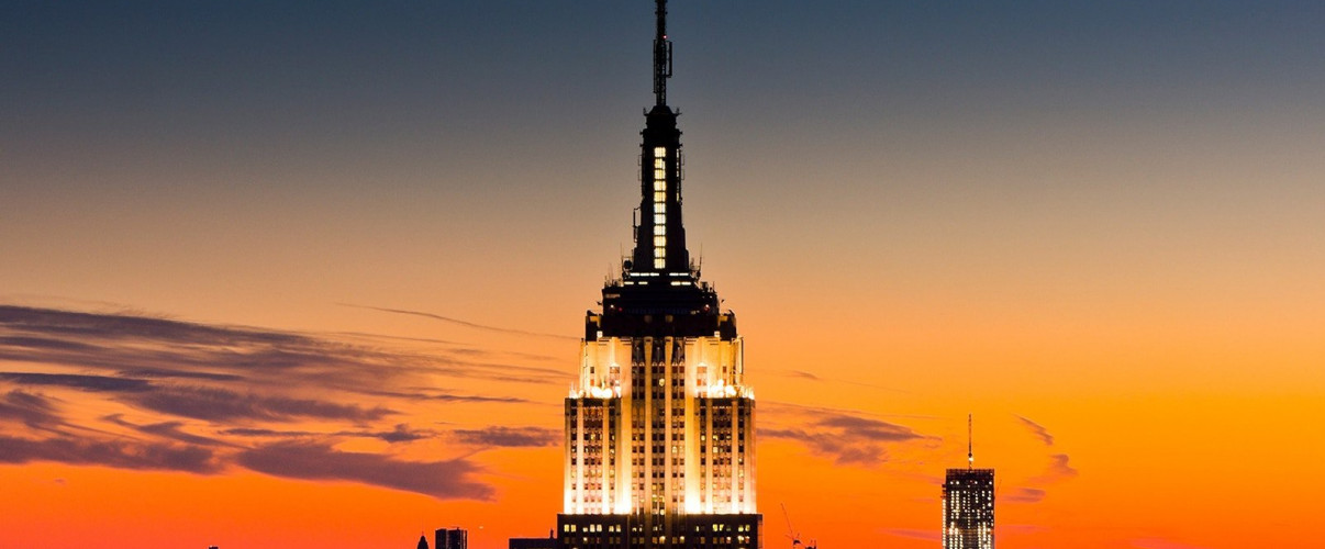 Empire State Building illuminated at night against the New York City skyline
