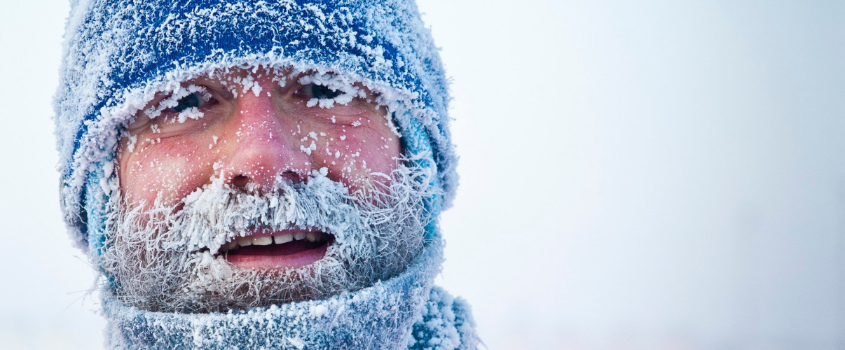 Man with frosted beard and hat in extreme cold