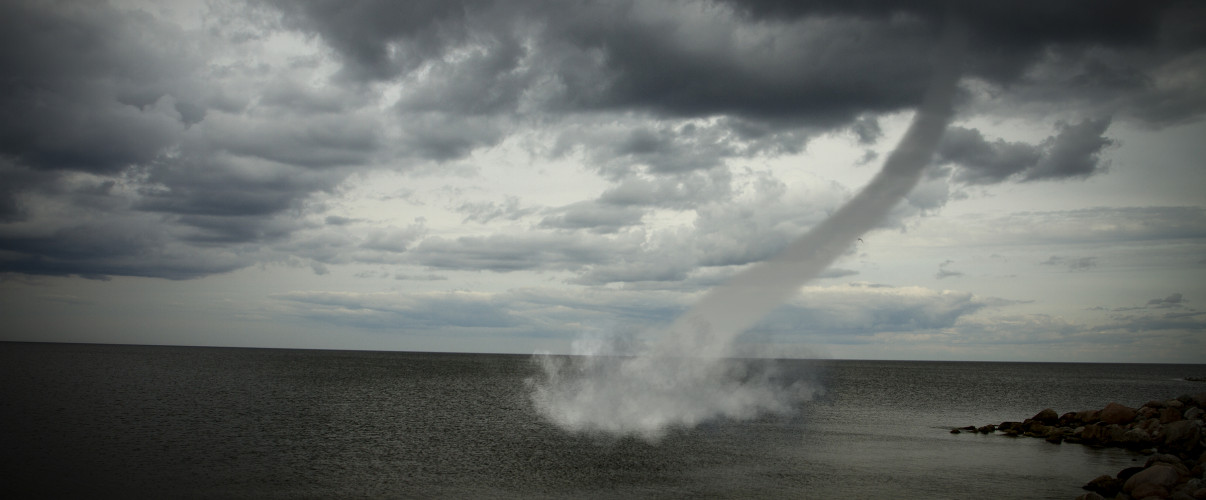 Tornado touchdown Powerful tornado touching down in rural landscape with dark stormy clouds
