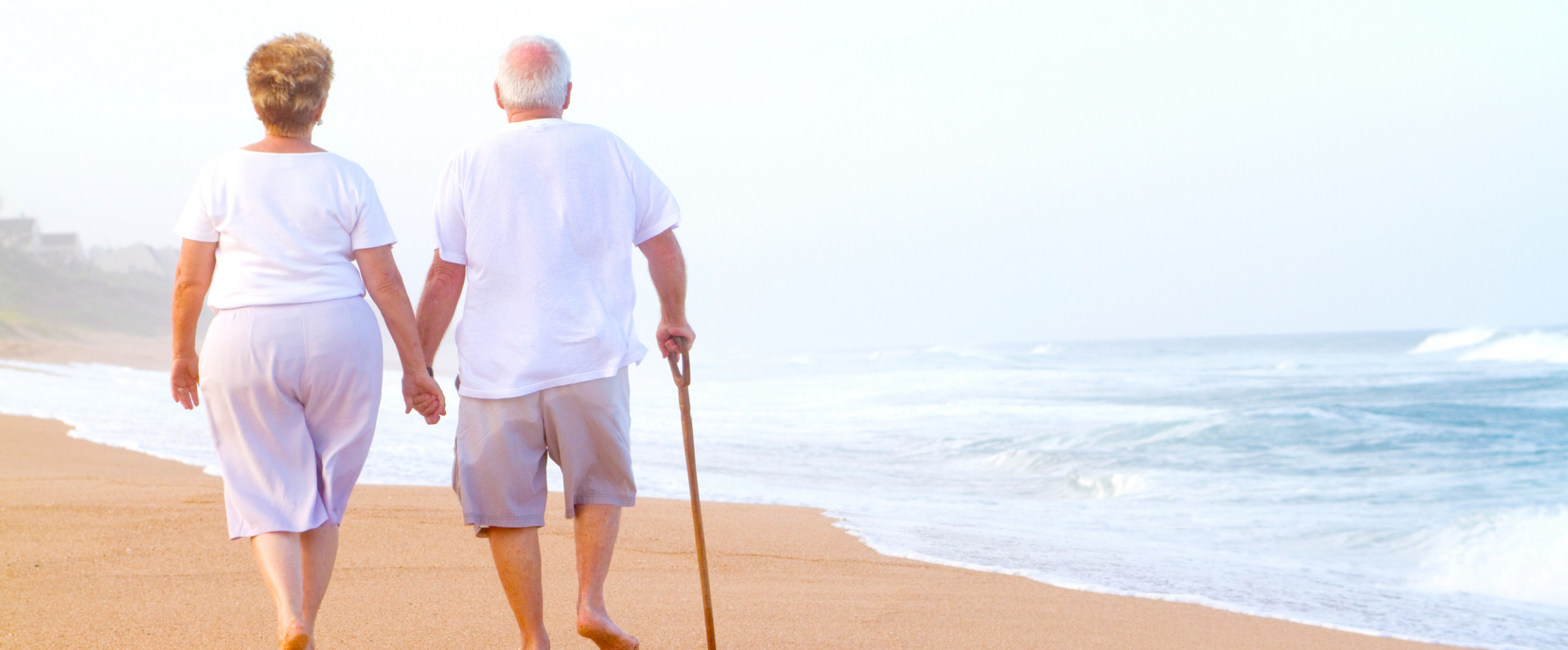 Elderly couple walking along the rocky Maine coastline