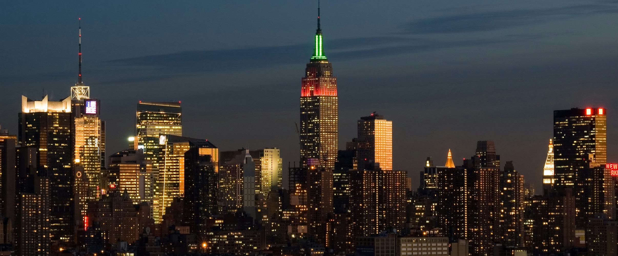 Illuminated Empire State Building standing tall in the New York City skyline at night