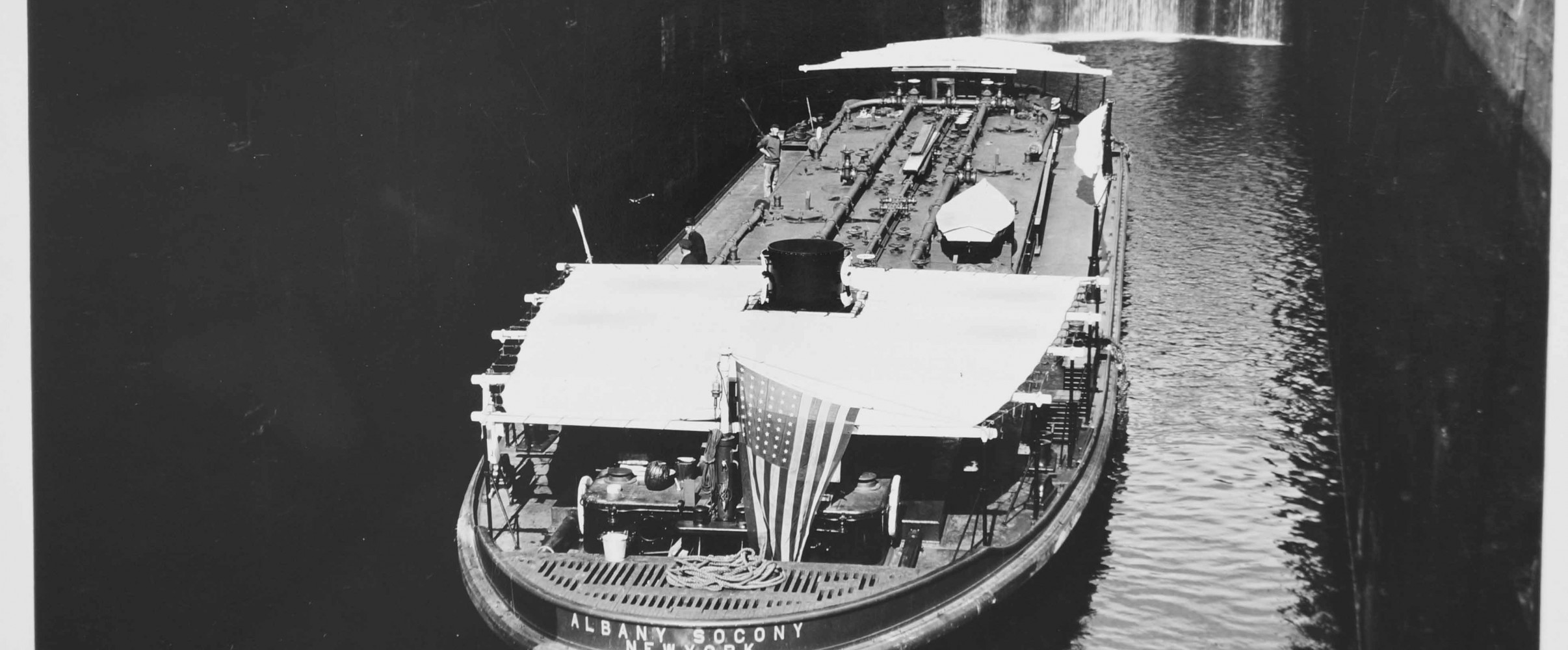 Historic boats navigating the Erie Canal with towpaths and locks visible