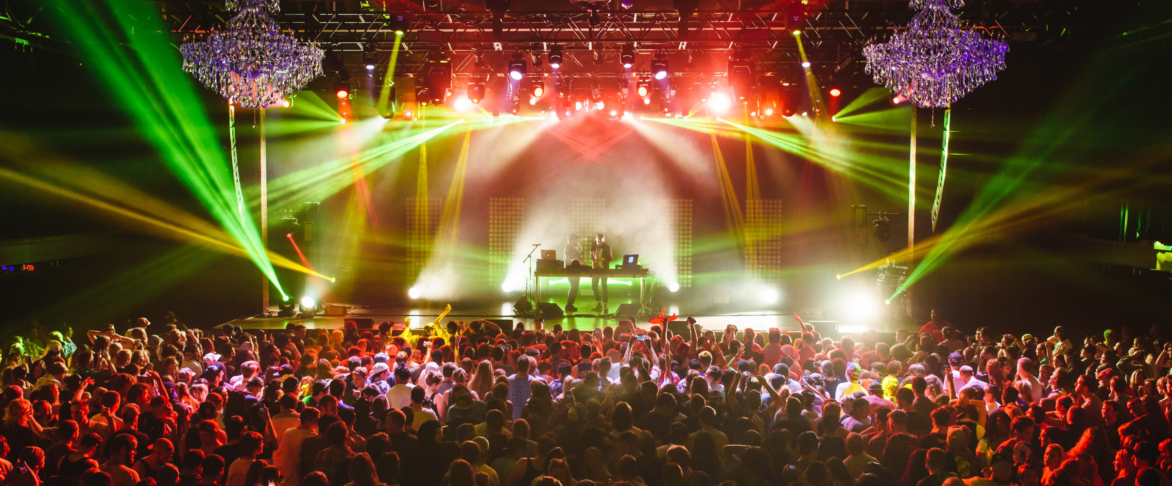 Live music venue Crowded concert venue with colorful stage lights and enthusiastic audience