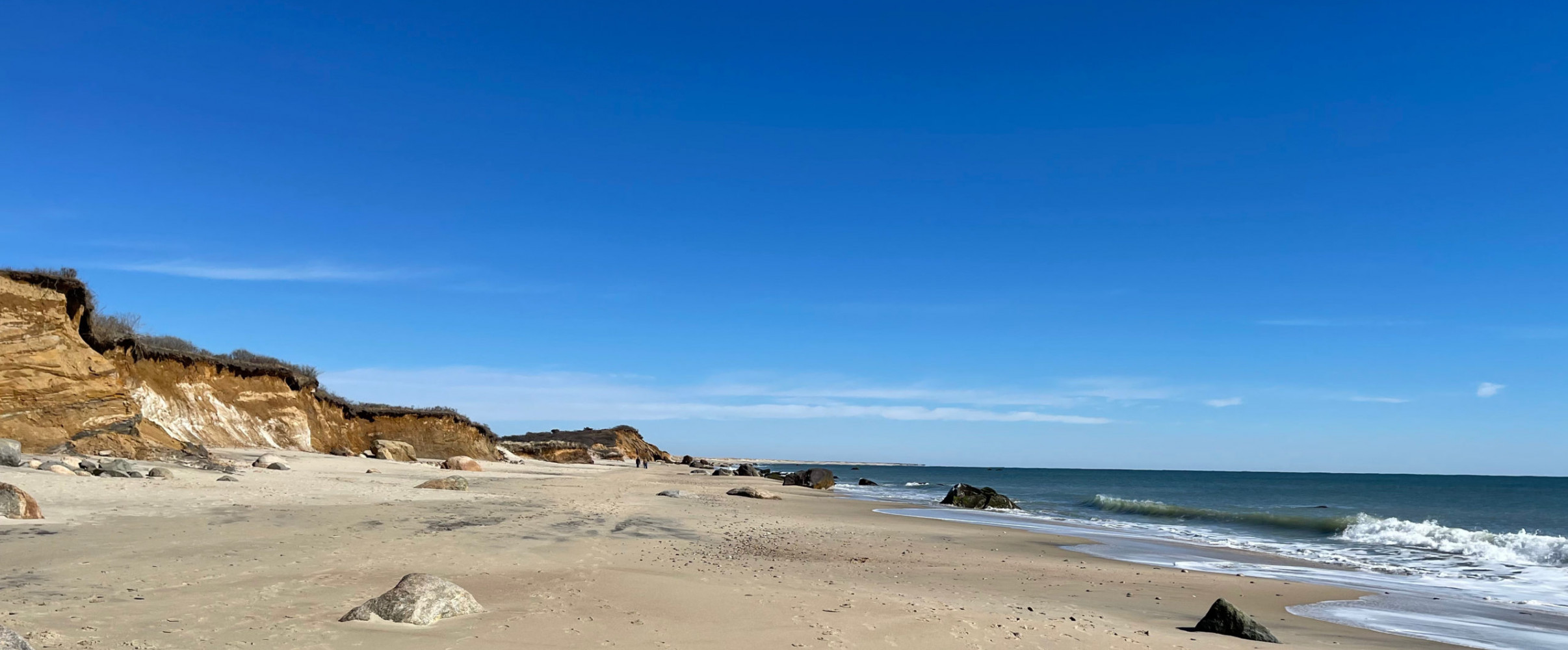 Scenic Martha's Vineyard coastline with colorful cottages along beach at sunset