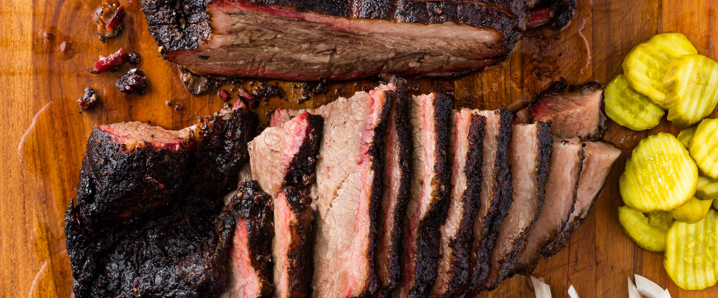 Sliced Texas brisket with bark on a wooden cutting board