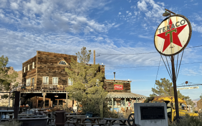 Abandoned buildings in Rhyolite, Nevada ghost town with desert mountains in background
