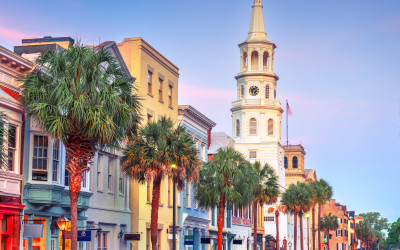 Colorful historic buildings along Charleston's waterfront with palm trees