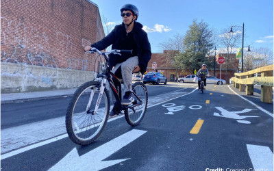 Cyclists riding on a protected bike lane in an urban setting