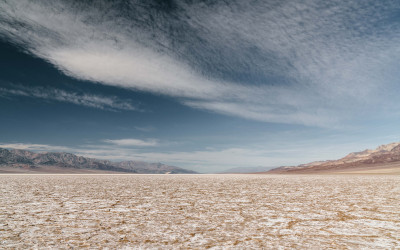 Cracked earth and sand dunes in Death Valley National Park, America's driest location