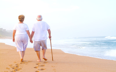 Elderly couple walking along the rocky Maine coastline