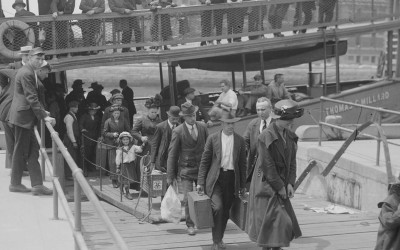 Historic black and white photograph of Ellis Island Immigration Station with crowds of immigrants