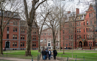 Harvard University's iconic red brick buildings with students walking through Harvard Yard