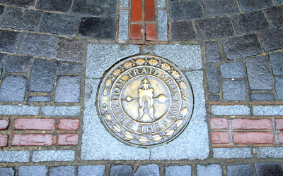 The red brick path of Boston's Freedom Trail winding through historic buildings