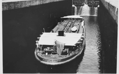 Historic boats navigating the Erie Canal with towpaths and locks visible