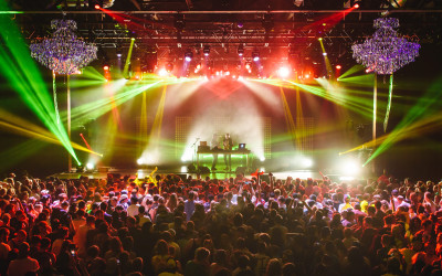 Crowded concert venue with colorful stage lights and enthusiastic audience