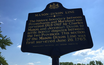 Historical stone marker of the Mason-Dixon Line with state boundary inscription