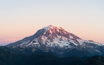 Snow-capped Mount Rainier volcano rising majestically against blue sky