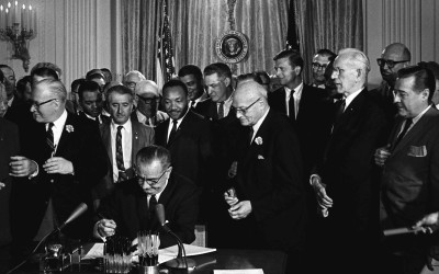 President Lyndon B. Johnson signing the Civil Rights Act of 1964 with Martin Luther King Jr. and other civil rights leaders present