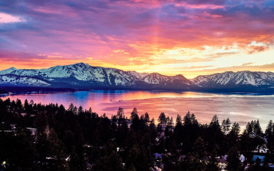 Stunning sunset view of Lake Tahoe with crystal clear blue water and mountains in background