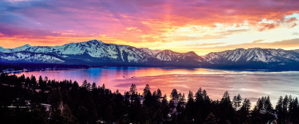 Stunning sunset view of Lake Tahoe with crystal clear blue water and mountains in background