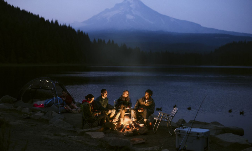 A tent perched on a hidden mountain ledge overlooking a pristine alpine lake