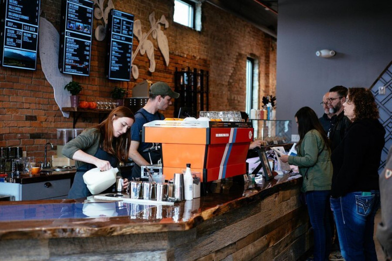 A warm, wood-filled Nashville coffee shop with guitar décor and customers being served at the counter