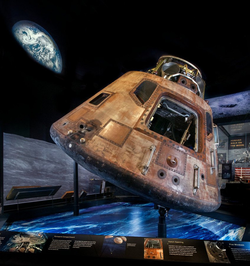 Apollo 11 command module on display at the National Air and Space Museum with visitors viewing the exhibit