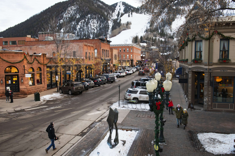 Aspen Colorado Christmas lights downtown Downtown Aspen with Victorian buildings decorated with white Christmas lights against snowy mountain backdrop