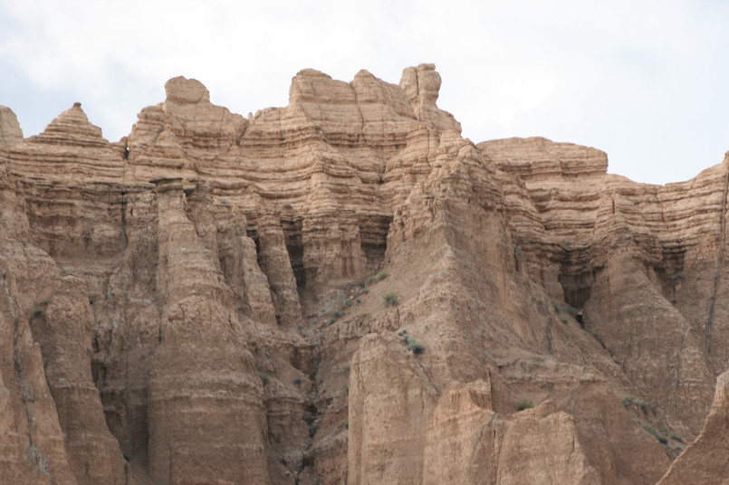 Layered badlands rock formations with exposed fossil layers