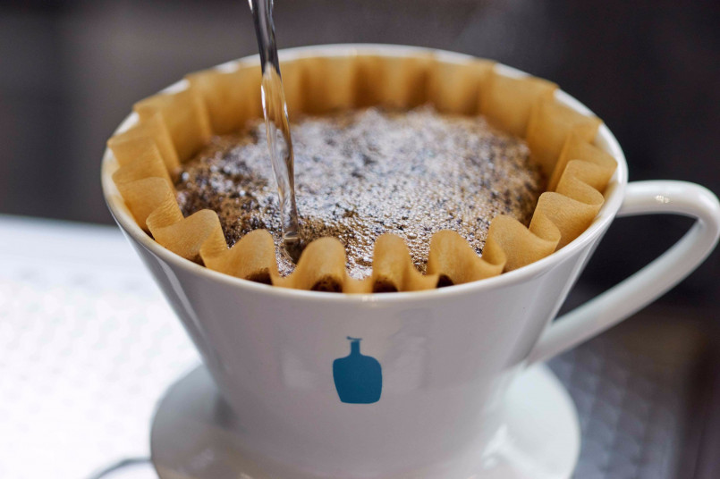 Blue bottle coffee san francisco, pour over coffee brewing Barista performing a precise pour-over coffee preparation at a minimalist San Francisco café