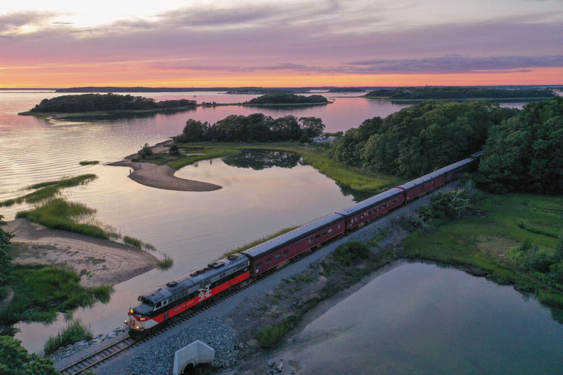 Cape Cod Central Railroad train passing alongside a scenic New England salt marsh with coastal birds and grasses visible