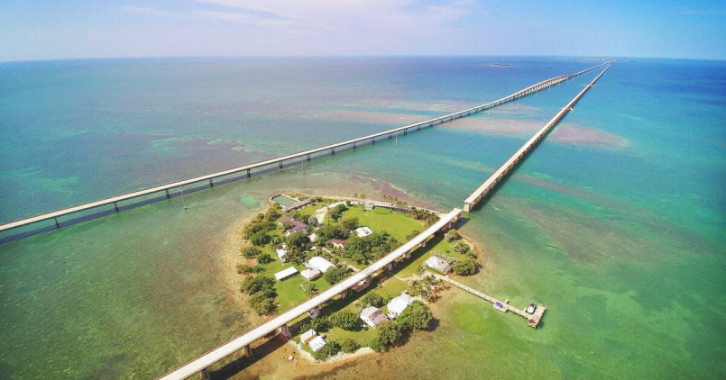 Cars driving across the Seven Mile Bridge with turquoise waters on both sides