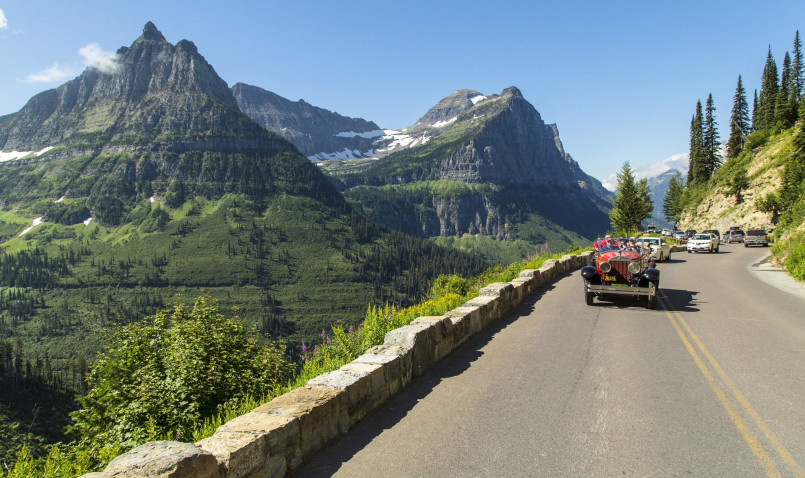 Cars traveling along the mountainous Going-to-the-Sun Road with stunning valley views