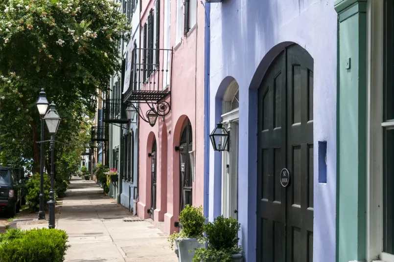 Charleston South Carolina historic homes rainbow row Rainbow Row in Charleston showing colorful historic Georgian townhouses along cobblestone streets