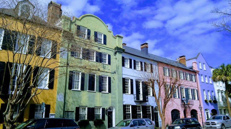 Colorful historic homes along Rainbow Row in Charleston with palm trees