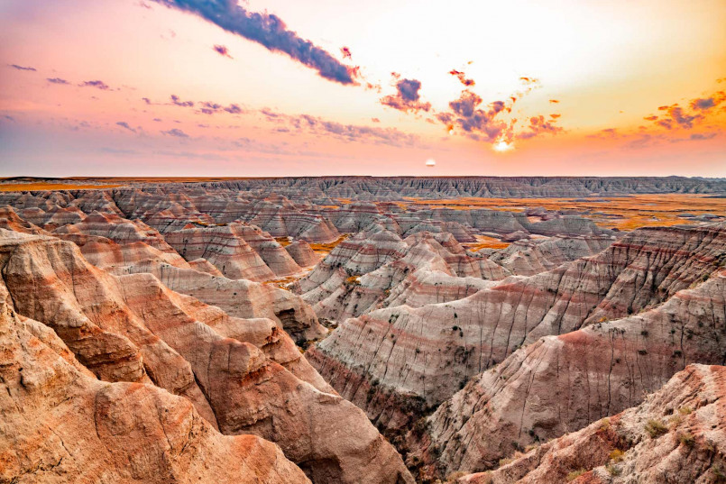 Colorful stratified rock formations in the Badlands illuminated by golden sunset light