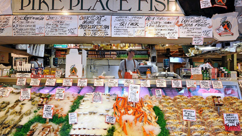Colorful vegetable and seafood displays at vendor stalls in Pike Place Market