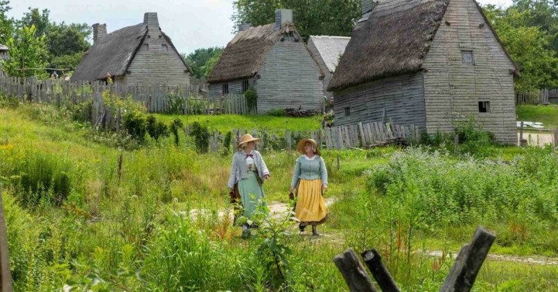 Costumed interpreters at Plimoth Patuxet demonstrating colonial life in recreated 17th century buildings