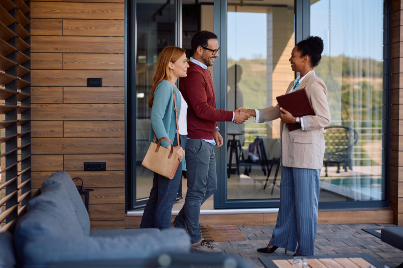 Young couple viewing potential home with real estate agent