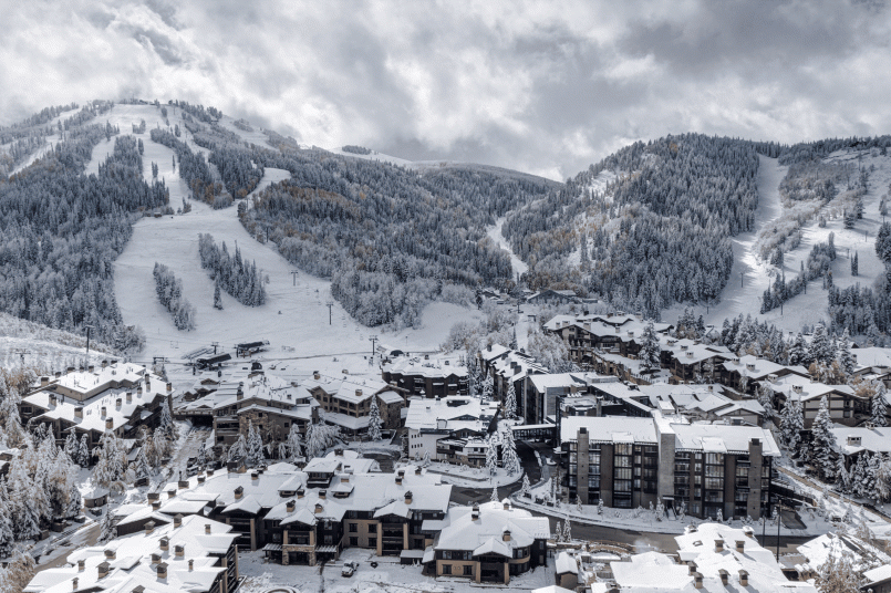 Skiers outside a luxury lodge at Deer Valley with staff attending to equipment