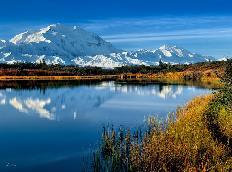 Majestic snow-capped Denali peak reflecting in the still waters of Wonder Lake on a clear morning