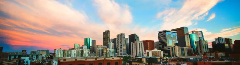 Denver Colorado skyline Rocky Mountains tech workers educated city Denver Colorado skyline with snow-capped Rocky Mountains, home to one of America's most educated workforces