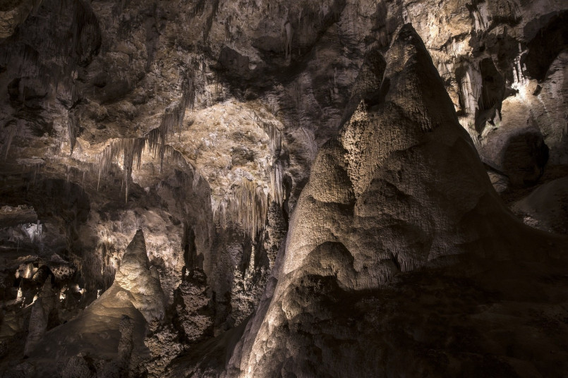 Dramatic limestone formations in Carlsbad Caverns illuminated to showcase their intricate details