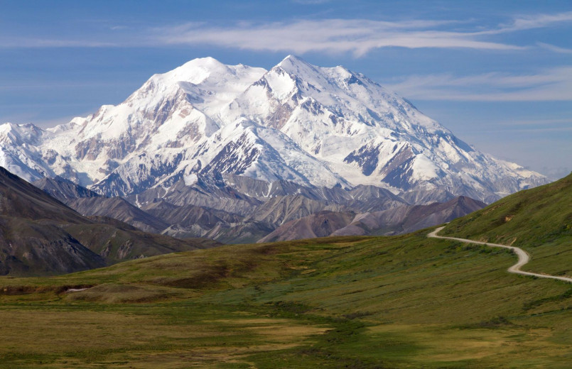 Dramatic view of Denali's summit rising above clouds with its distinctive double-peak appearance