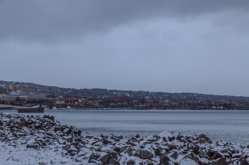 Duluth Minnesota winter lakefront Snow-covered Duluth shoreline with Lake Superior partially frozen and city buildings visible on the hillside