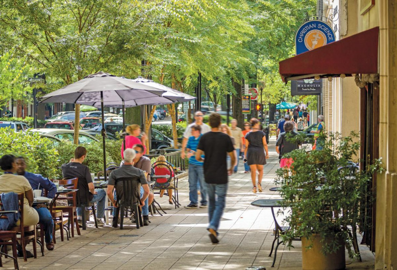 Evening view of Greenville's Main Street lined with bustling restaurants and outdoor dining